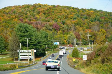 Tunkhannock, Pennsylvania, ABD - 20 Ekim 2020 - 6. yolda trafik sonbahar yeşilliklerinin çarpıcı renkleriyle çevrili