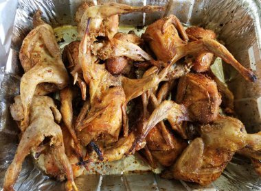 Alüminyum bir kabın içinde kızarmış bıldırcın yığını.