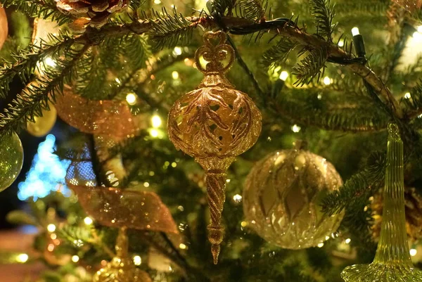 Χρυσό Χρώμα Στολίδια Ένα Φωτισμένο Χριστουγεννιάτικο Δέντρο — Φωτογραφία Αρχείου
