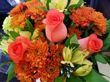 Çiçek buketinde güzel pembe güller ve turuncu papatyalar
