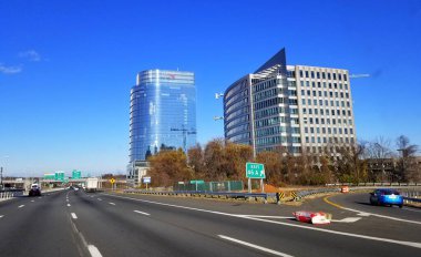 McLean, Virginia, U.S.A - December 6, 2020 - The view of the traffic on Interstate 495 by the Capital One building clipart