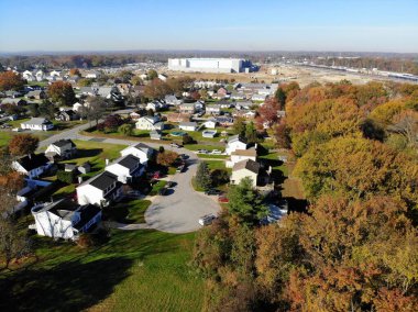 Newport, Delaware, ABD - 11 Kasım 2020 Mahallenin ve sonbahar yeşilliklerinin çarpıcı renkleriyle çevrili yeni Amazon Deposunun havadan görünüşü