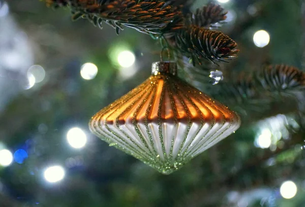 Ένα Χρυσό Στολίδι Σφαίρα Ένα Φωτισμένο Χριστουγεννιάτικο Δέντρο — Φωτογραφία Αρχείου