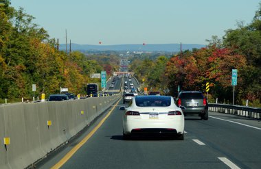 Allentown, Pennsylvania, U.S.A - October 17, 2020 - The view of the traffic on Interstate 476 South overlooking the striking colors of fall foliage clipart