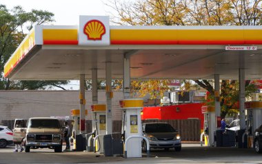Chicago, Illinois, ABD - 14 Ekim 2018 Shell benzin istasyonundaki arabalarına benzin koyan sürücüler