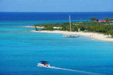 The view of beautiful blue ocean, boats and white sandy beaches along the bay near Grand Turk, Turks & Caicos