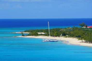 The view of beautiful blue ocean, a yacht and white sandy beaches along the bay near Grand Turk, Turks & Caicos