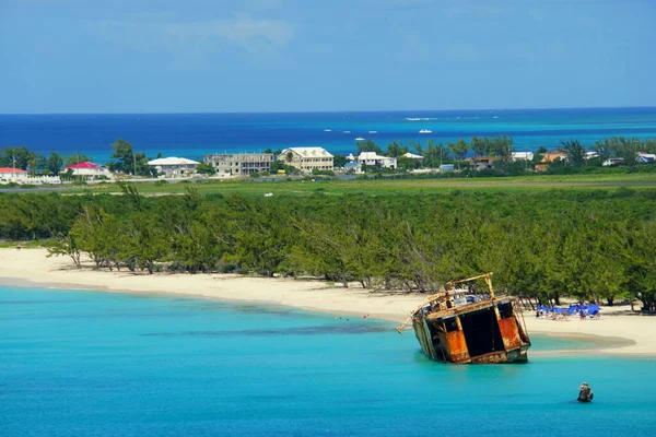 The view of beautiful blue ocean, an old fishing boat and white sandy beaches of Grand Turk, Turks & Caicos
