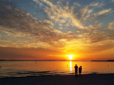 Cape Coral, Florida, ABD yakınlarında gün batımını izleyen bir çiftin silueti.