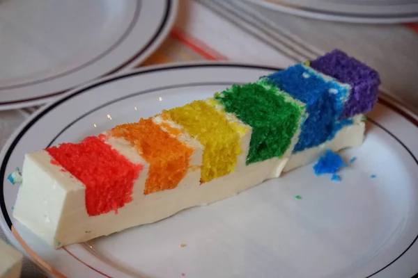 Una Rebanada Pastel Arco Iris Encima Plato Blanco — Foto de Stock