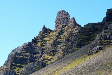 Yaz boyunca doğu fiyortları, İzlanda yakınlarındaki dağların tepesindeki güzel kaya oluşumları.