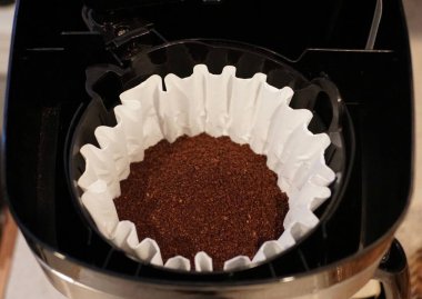 Kahverengi kahve tozu beyaz kağıt filtrede.