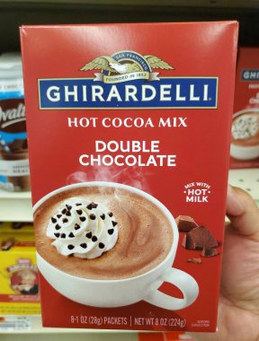 Delaware, U.S.A - 15 Ekim 2025 - Bir kutu Ghirardelli Duble Çikolatalı Sıcak Kakao karışımı, üzerine krem şanti ve mini çikolata parçacıkları sergilenen sıcak kakao.