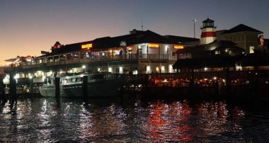Madeira Sahili, Florida, ABD - 8 Kasım 2025 - Hooters restoranlarının ve John 's Pass Boardwalk civarındaki yerel mağazaların manzarası gece aydınlandı