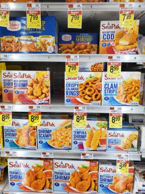 Wilmington, Delaware, ABD - 2 Aralık 2025 - Dondurulmuş deniz ürünleri marketteki dondurucuda karides, morina, kalamar ve yengeç köftesi satışı