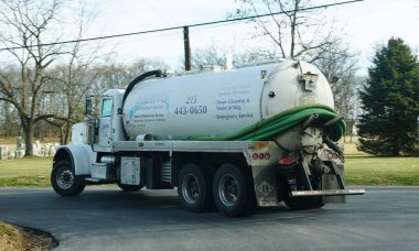 Sellersville, Pennsylvania, ABD - 13 Aralık 2025 - Franc Environmental Inc. 'in septik servis kamyonu, atık su yönetimi sağlıyor, mezarlık yakınındaki yoldan dönüyor.