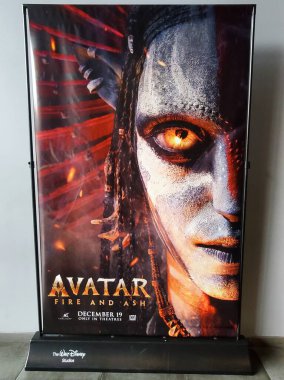Wilmington, Delaware, ABD - 21 Aralık 2025 - 'Avatar - Fire and Ash' filminin promosyon afişi, yoğun Navi karakterinin parlak gözleri ve közle dolu arka planı