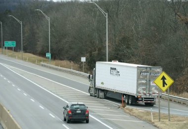 Quakertown, Pennsylvania, ABD - 26 Aralık 2025 Prime Inc yarı-kamyon hareket halindeki bir araçla güvenli bir şekilde otobandan çıkıyor.