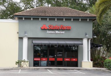 Sarasota, Florida, ABD - 4 Ocak 2026 - Ajan James Meroni tarafından işletilen bir Devlet Çiftliği Sigorta Ofisi, kırmızı ve beyaz kolonların yer aldığı