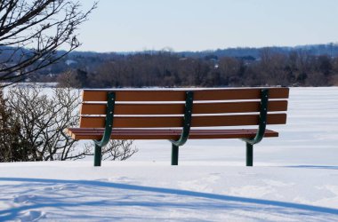 Karlı bank donmuş göle bakıyor. Greenlane Reservoir, Pennsburg, Pennsylvania, ABD yakınlarındaki huzurlu bir kış ortamında yansımaya yol açıyor.
