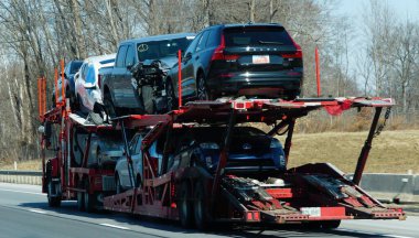 Wilmington, Delaware, ABD - 28 Şubat 2026 - Volvo ve Toyota 'nın da dahil olduğu hasarlı araçları kurtarma, onarım veya açık artırma işlemleri için taşıyan bir araba taşıyıcısı