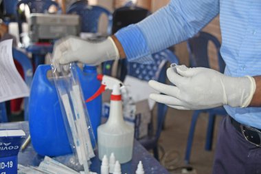 Burdwan Town, Purba Bardhaman İlçesi, Batı Bengal / Hindistan - 01.05.2021: Sağlık çalışanları COVID-19 enfeksiyonu kapıp kapmadıklarını görmek için asimptomatik gazetecilerden örnekler toplayarak antijenleri test ediyorlar (Roman Coronavirus).