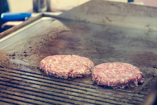 Chef preparare gustosi hamburger allo stand all'aperto . — Foto Stock