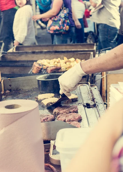 Chef preparare gustosi hamburger allo stand all'aperto . — Foto Stock