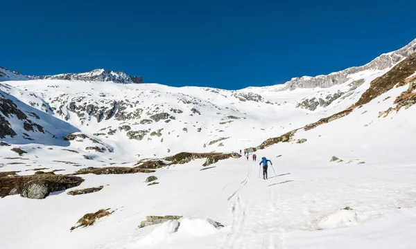 Skifahrer erklimmen einen Berghang. — Stockfoto