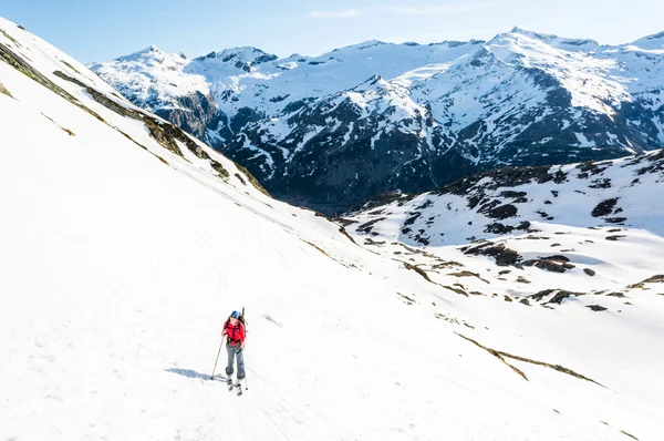 Esquiador feminino ascendendo uma encosta da montanha . — Fotografia de Stock