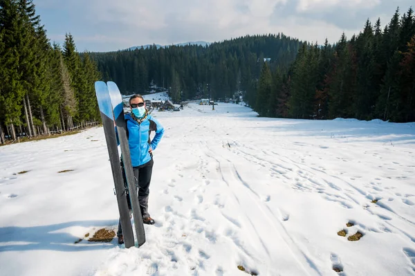 Skieuse posant avec un appât de skis portant un masque protecteur. — Photo