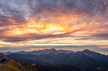 Uzaktaki yüksek tepenin üzerinde yükselen güneşin muhteşem dağ manzarası..