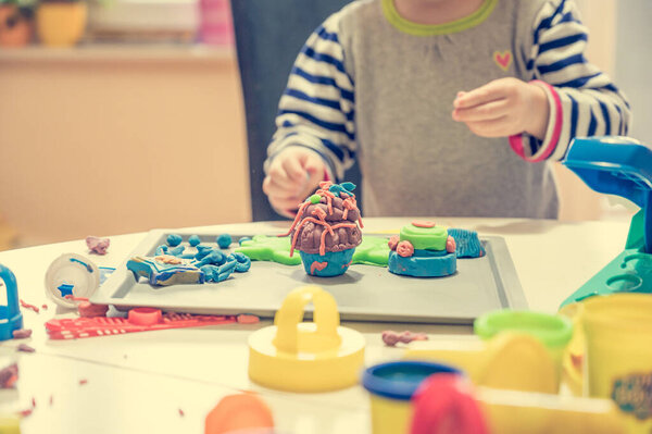 Detail of childs hand working with play dough.