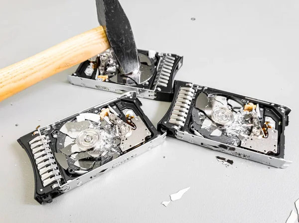 テーブルの上に皿を粉砕した3つのハードディスクドライブ. — ストック写真