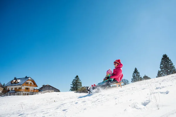 母女在覆盖着雪的斜坡上滑行. — 图库照片