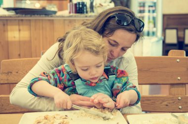Şirin sarışın kız annesiyle restoranda etli erişte çorbası içiyor..
