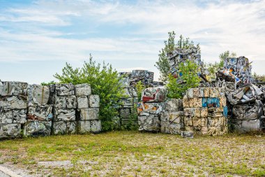 Büyük küpler halinde sıkıştırılmış alüminyum döküntüler yığınlar halinde çöp alanı oluşturur..