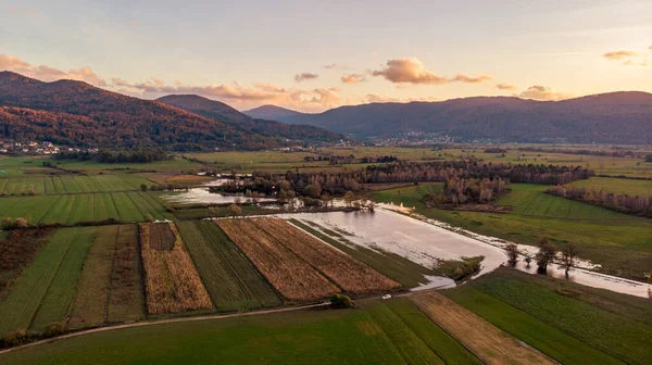 Spectacular aerial panorama of river flowing through fields at sunset. — Stock Photo, Image