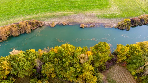 Drop down view of river flowing through fields after harvest. — Stock Photo, Image