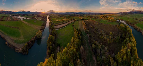 Ефектна повітряна панорама річки, що протікає через поля на заході сонця . — стокове фото