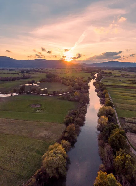 Espectacular panorama aéreo del río que fluye a través de los campos al atardecer. —  Fotos de Stock