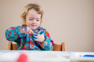 Boyalı fırça ve parmaklar kullanarak acı çeken tatlı sarışın kız..