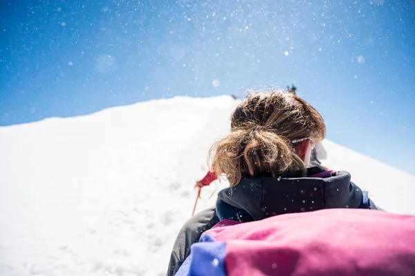 Touw teamlid standpunt met bergbeklimmers wandelen op sneeuw en ijs bij zonnig weer. — Stockfoto