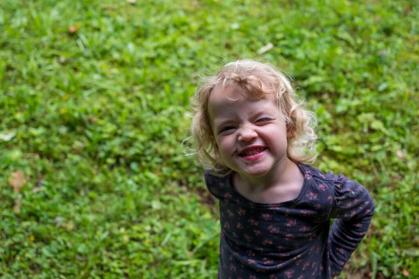 Drop down portret van schattig meisje het maken van gezichten. — Stockfoto