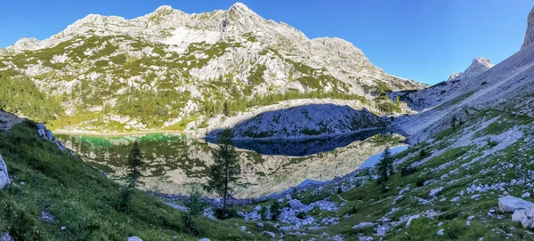 Picturesque crystal clear mountain lake surrounded with peaks. — Stock Photo, Image