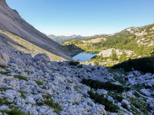 Pintoresco lago de montaña cristalino rodeado de picos. —  Fotos de Stock