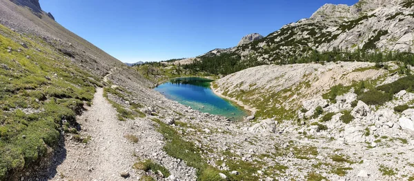 Pintoresco lago de montaña cristalino rodeado de picos. —  Fotos de Stock