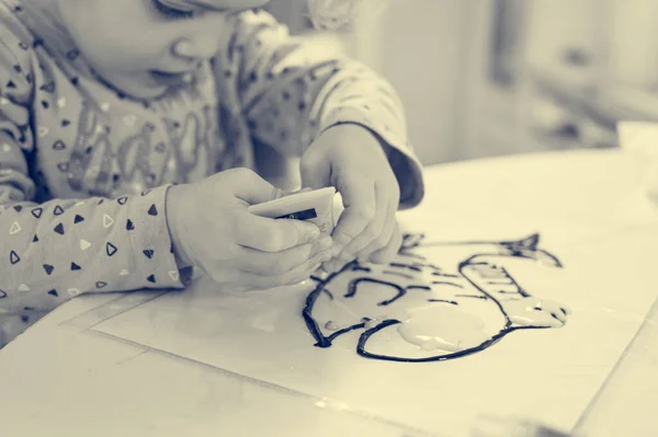 Menina bonito desenhar um peixe usando cores de vidro em casa. — Fotografia de Stock