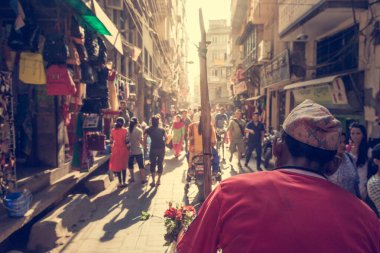 İşlek bir caddede kırmızı tişört giyen Rikshaw şoförü.