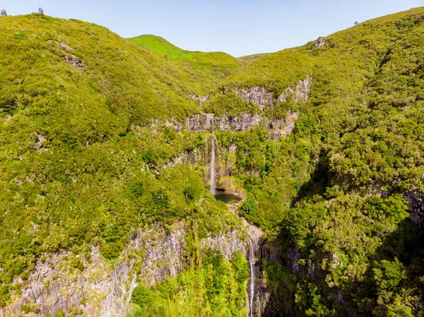 Flygfoto över dubbla vattenfall omgiven av vulkaniska väggar och skog. — Stockfoto
